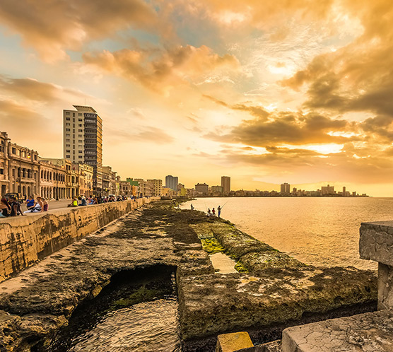 Beautiful sunset in Havana with a view of cubans and tourists along the Malecon avenue